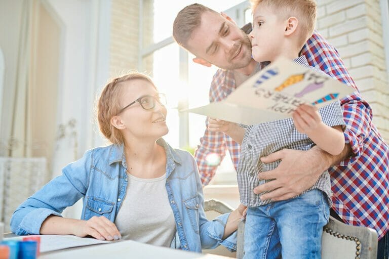 Family in kitchen in front of window