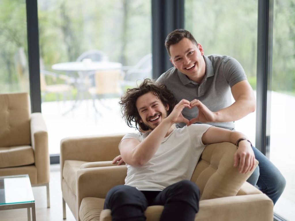 Gay couple enjoying leisure time in clean living room