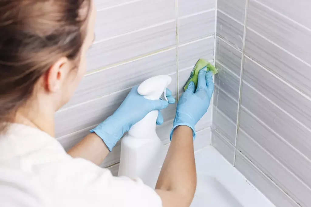 Woman cleaning bathroom tiles